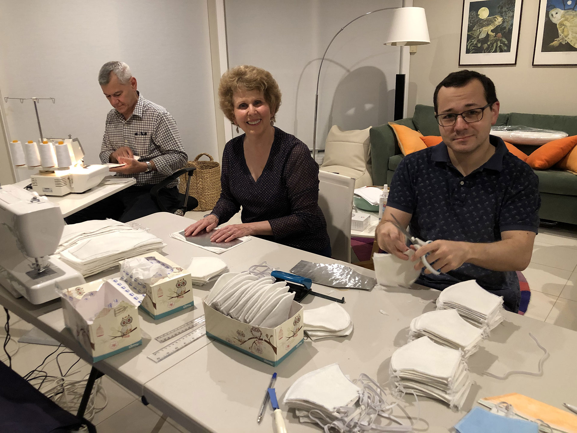 Gabe Gallo and Dr Trish Baker with their son Robert Gallo work on making fabric masks for patients